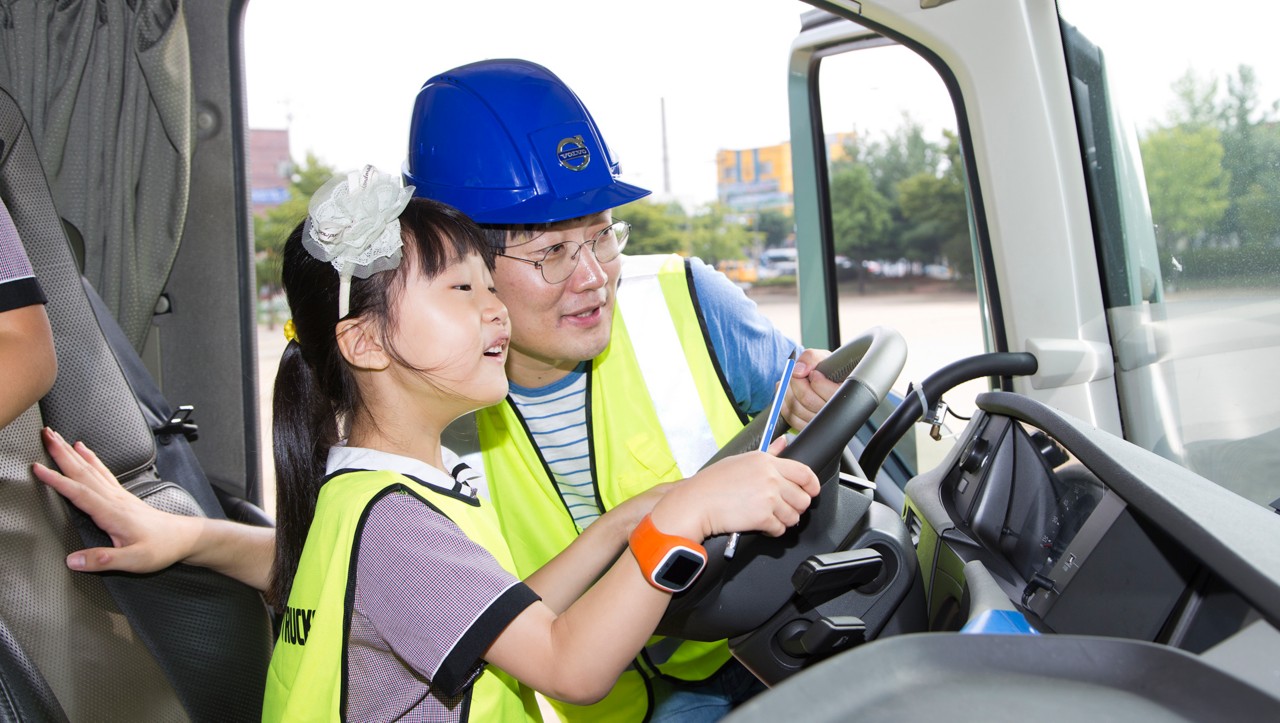 Egy férfi és a teherautó vezetőülésében ülő gyermek